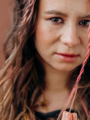 Close-up of a woman with braided hair meditating with a peaceful expression.